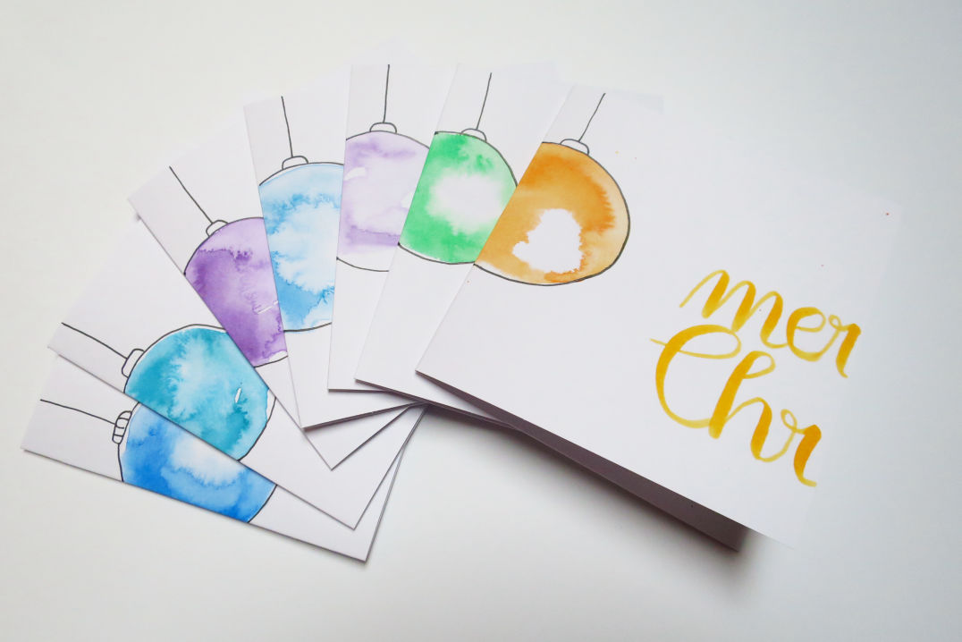 Weihnachtskarten "Merry Christmas" aufgefächert mit Christbaumkugeln in Aquarell.